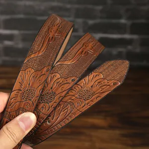 Close-up of vintage brown PU leather belt featuring embossed floral and bull head patterns
