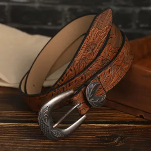 Detailed close-up of vintage embossed floral pattern on brown PU leather belt strap