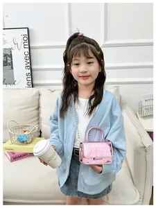 Close-up of pink metallic girls' crossbody bag featuring crocodile pattern and chain strap