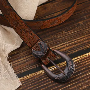Detailed macro view of vintage bronze buckle with floral embossed brown PU leather belt