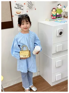Detailed view of kids gold mini crossbody bag with crocodile texture and chain strap