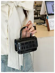 Detail of black mini PU crossbody bag with crocodile pattern and silver bead chain strap