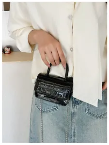 Detail of girls mini black crocodile pattern handbag with silver metal ball chain strap