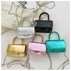 Flat lay of mini crocodile pattern crossbody bags in silver gold black pink and green