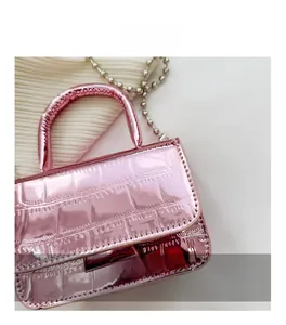 Detail of pink metallic handbag with faux crocodile skin texture and silver bead chain