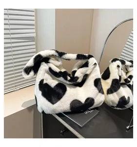 Détail de la texture en fausse fourrure douce et imprimé cœur noir du sac cabas
