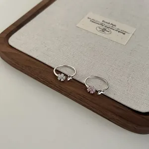 Detail of S925 silver flower rings with pink teardrop zircon and butterfly design
