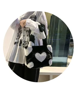Détail du sac cabas doux en peluche noir et blanc avec motif cœur dans un décor urbain