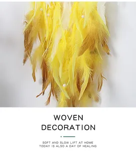 Detailed close-up of handmade yellow gradient feathers and white beads on a dream catcher