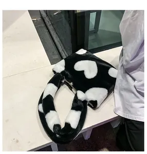 Gros plan du sac fourre-tout en peluche noir et blanc avec motifs de coeurs