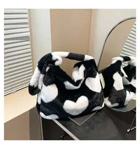 Détail d'un sac cabas en fausse fourrure avec motifs de cœurs noirs et blancs