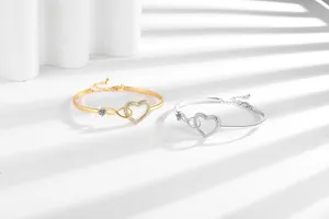 Detailed view of infinity heart bracelets with sparkling cubic zirconia in gold and silver