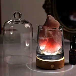 Macro shot of natural pink crystal stones in glass with warm glowing wooden LED base