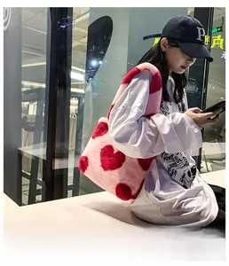 Photo extérieure d'un sac cabas en peluche rose avec fausse fourrure et cœurs rouges