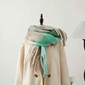 Detail of mint green and beige plaid scarf with soft brushed texture and long tassels