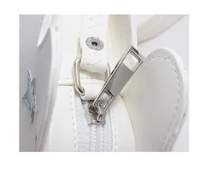 Détail du sac en cuir PU blanc avec fermeture éclair argentée et écussons étoiles laser