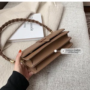 Détail de la poignée tressée et de l'intérieur multicouche du sac marron vintage