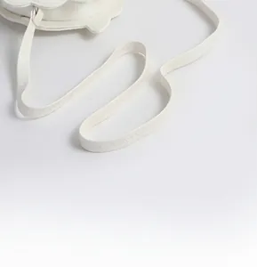 Détail de la bandoulière en cuir PU blanc avec couture décorative précise en zigzag