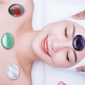 Close-up of polished oval amethyst and jade healing stones for professional facial spa therapy