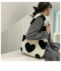 Détail du sac cabas en peluche montrant la texture douce et le motif cœur noir
