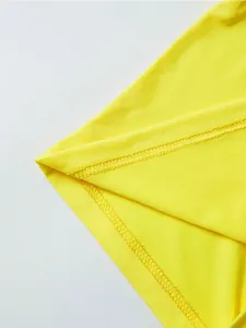 Detail of high-quality double-needle stitching on bright yellow knit fabric hemline