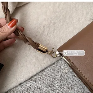 Détail d'un sac en cuir marron vintage avec fermoir doré et bandoulière tressée