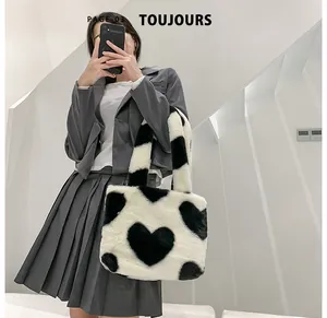 Détail du sac cabas en peluche à motif cœurs, fausse fourrure douce et anses noires larges