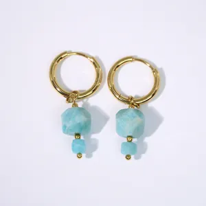 Dettaglio di orecchini in acciaio inossidabile oro 14K con pietre sfaccettate azzurre