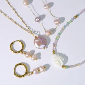 Set dettagliato di collane e orecchini di perle dorate con perle barocche e foglia di madreperla