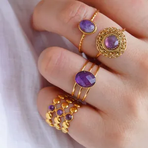 Elegantes Set aus 4 verstellbaren Amethyst-Ringen in Goldoptik auf weißem Stoffdekor
