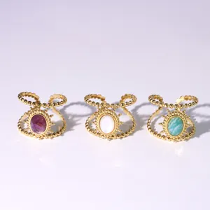 Detail of bohemian gold rings featuring sunburst beads and colorful oval natural stones