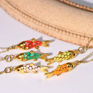 Detailansicht von fünf bunten Emaille-Fischanhängern an eleganten Goldketten