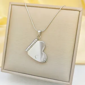 Polished stainless steel heart locket necklace with elegant silver snake chain on silk