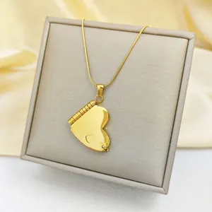 Close-up of golden heart locket necklace with fine snake chain on jewelry box