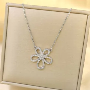 Macro detail of silver floral pendant necklace with sparkling cubic zirconia on a velvet box