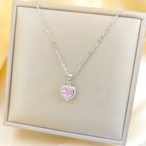 Makroaufnahme eines rosa Herz-Zirkon-Anhängers mit Diamant-Halo an einer Silberkette