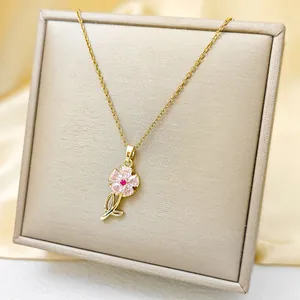 Detailed close-up of a gold sunflower pendant with pink petals on silk background