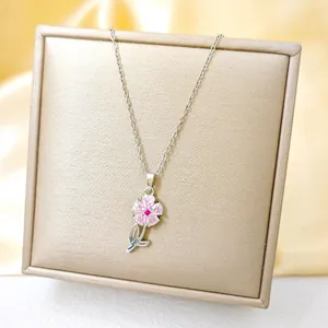 Detailed view of pink zircon flower pendant with silver stem on champagne satin