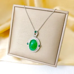 Élégant collier à pendentif ovale vert émeraude avec diamants sur tissu de soie dorée