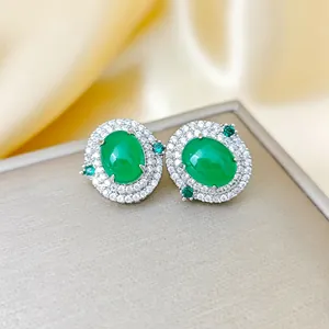 Boucles d'oreilles émeraude élégantes avec double halo de diamants sur soie dorée