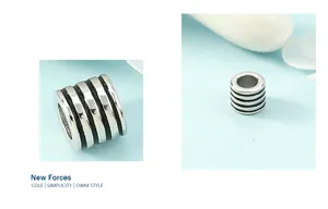 Detailed close-up of a silver cylindrical bead with black stripes for necklaces