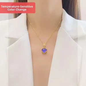Thermosensitive color-changing fox pendant necklace with gold chain on white blazer