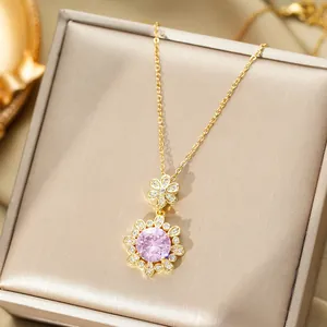 Vue détaillée du collier fleur doré avec pierre rose sur un support en soie élégant