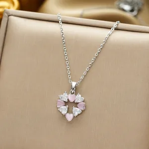 Pink heart and white crystal floral wreath pendant in titanium steel on a jewelry tray