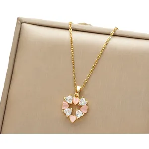 Golden heart necklace featuring pink opals and white zircons on a jewelry box gift display