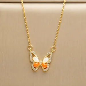 Close-up of titanium steel butterfly pendant with orange opal and sparkling zircons