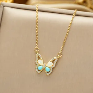 Detailed close-up of a titanium steel butterfly pendant with blue stones and opal inlay