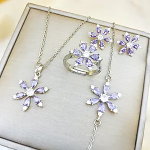 Detailed view of the flower-shaped jewelry set with purple gemstones and silver finish