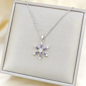 Macro shot of 18K gold plated snowflake pendant necklace with purple zircon stones