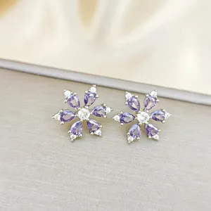 Macro view of purple snowflake stud earrings with teardrop zircon petals and silver base